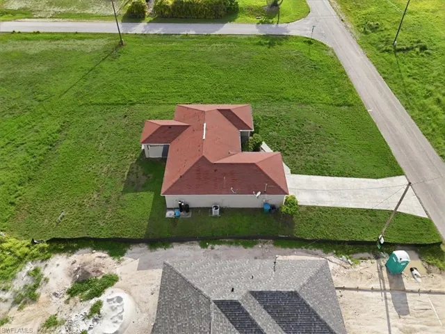 Single-story residence featuring a red shingle roof and light-colored exterior walls