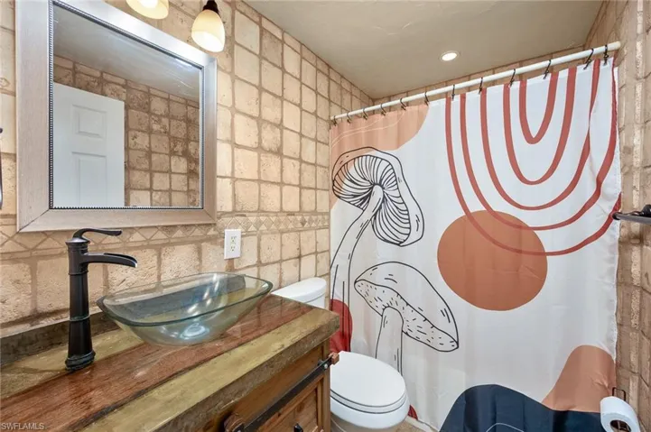 Bathroom with tile walls, vanity, and toilet