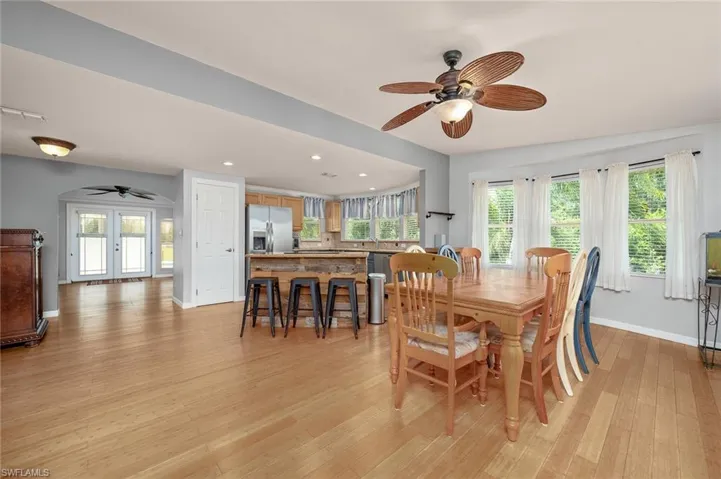 Dining space featuring french doors, light wood-type flooring, and ceiling fan