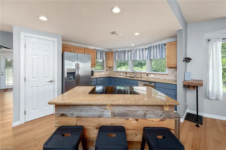 Kitchen with appliances with stainless steel finishes, backsplash, light brown cabinetry, and a wealth of natural light
