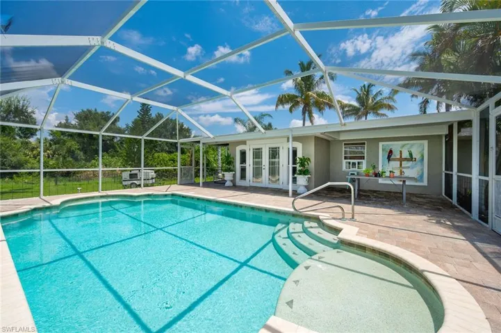 View of pool featuring a lanai, french doors, and a patio area