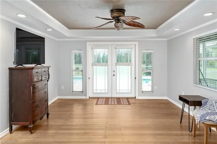 Foyer entrance featuring light wood-type flooring, ceiling fan, and a raised ceiling