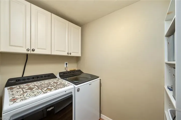 Laundry area with washing machine and clothes dryer and cabinets