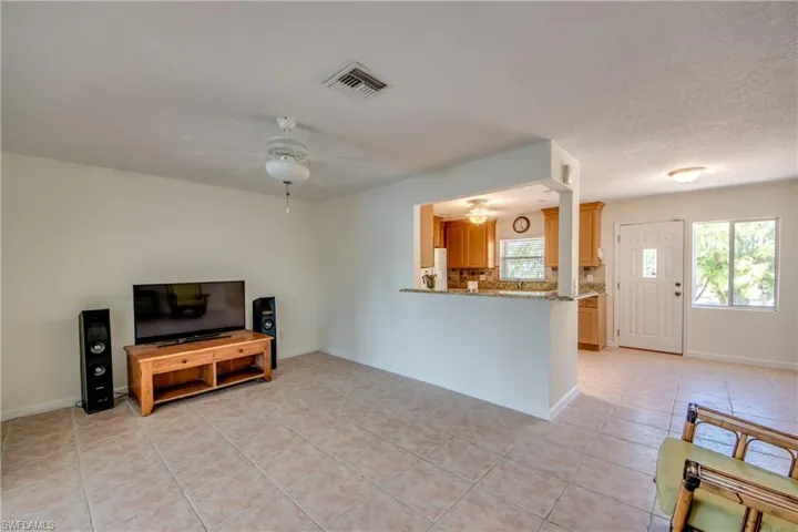 Living room with light tile patterned flooring and ceiling fan