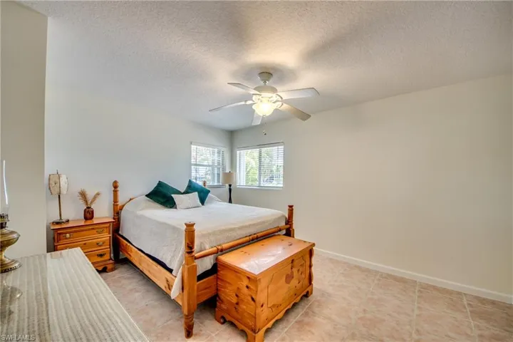 Bedroom featuring light tile patterned flooring, a textured ceiling, and ceiling fan