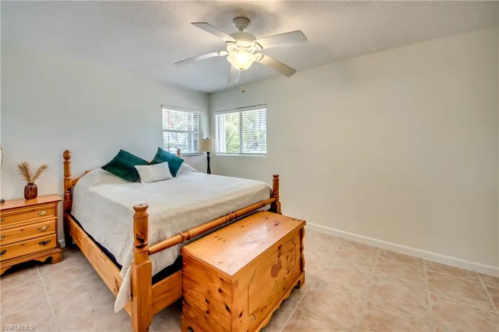 Bedroom with light tile patterned floors, a textured ceiling, and ceiling fan