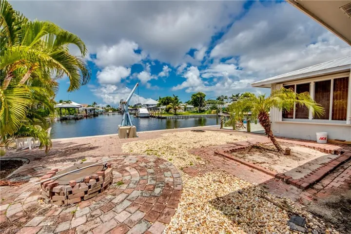 View of patio with a fire pit and a water view