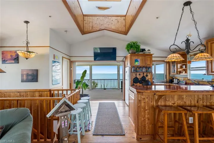 View of Living room looking into the kitchen, with views of cupola and attached deck.