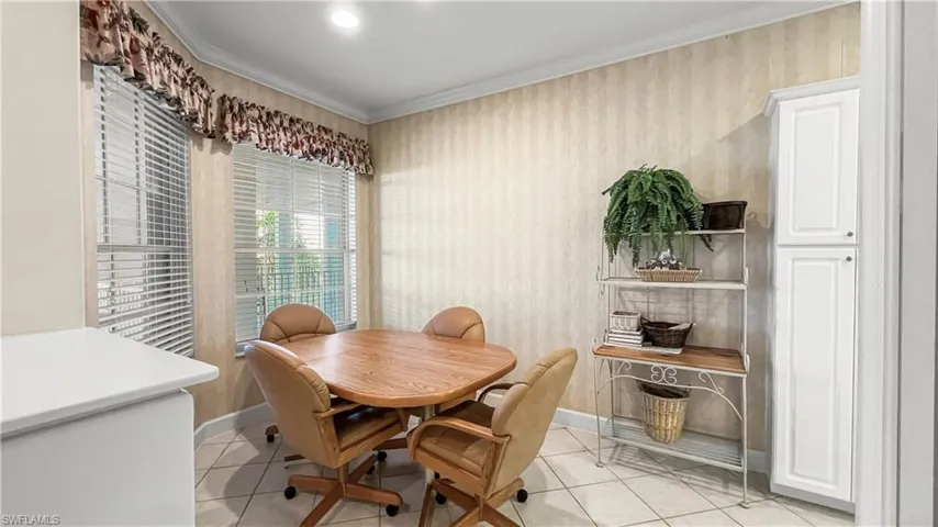 Dining room with crown molding and light tile patterned floors