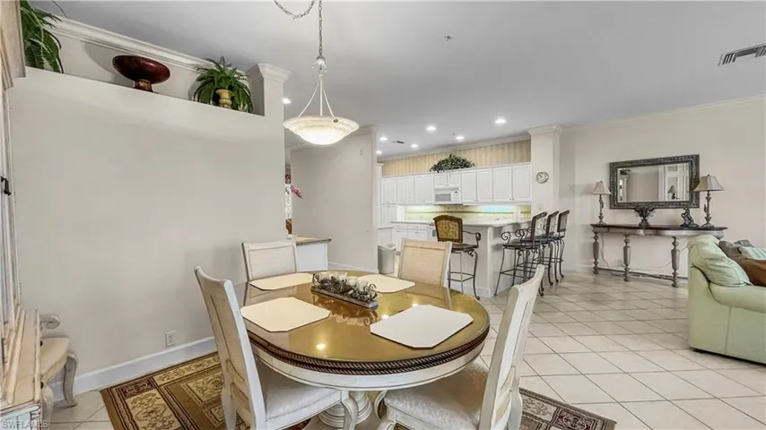 Tiled dining room featuring crown molding