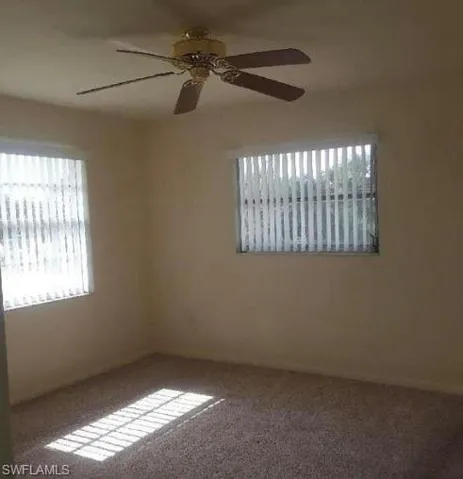 Carpeted spare room with a ceiling fan