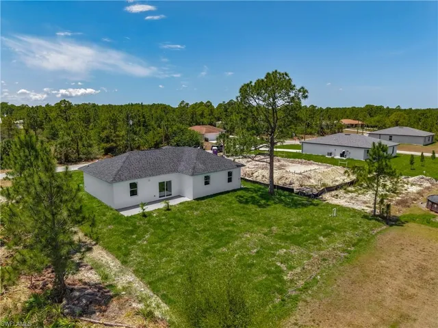 Aerial view of property and surrounding area with a forest