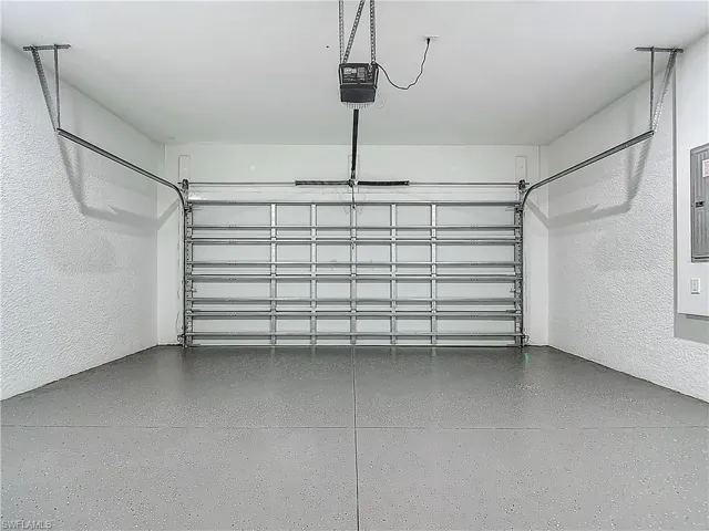Garage with a textured wall and a garage door opener