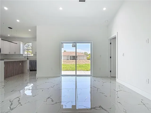 Unfurnished living room featuring light marble finish flooring and recessed lighting