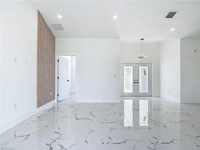 Unfurnished room featuring light marble finish flooring, recessed lighting, baseboards, and french doors