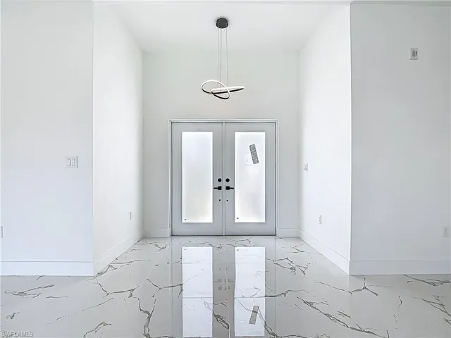 Entryway with light marble finish flooring and baseboards