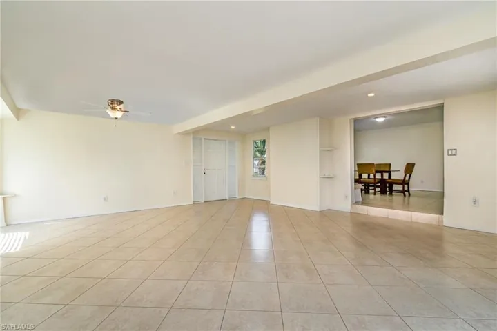 Spare room featuring light tile patterned flooring, built in features, and a ceiling fan