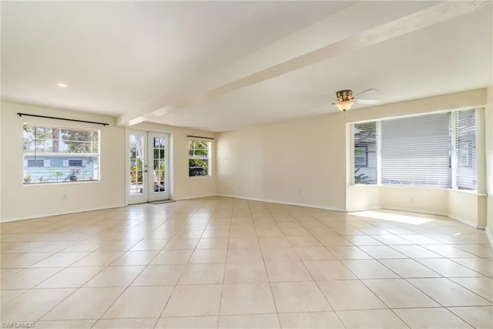 Unfurnished room with baseboards, a ceiling fan, and light tile patterned floors