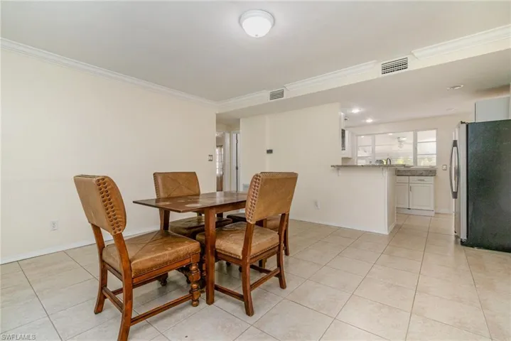 Dining room with baseboards, visible vents, ornamental molding, and light tile patterned floors