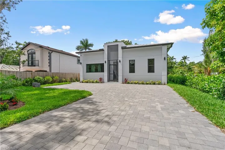 Modern home featuring stucco siding and decorative driveway