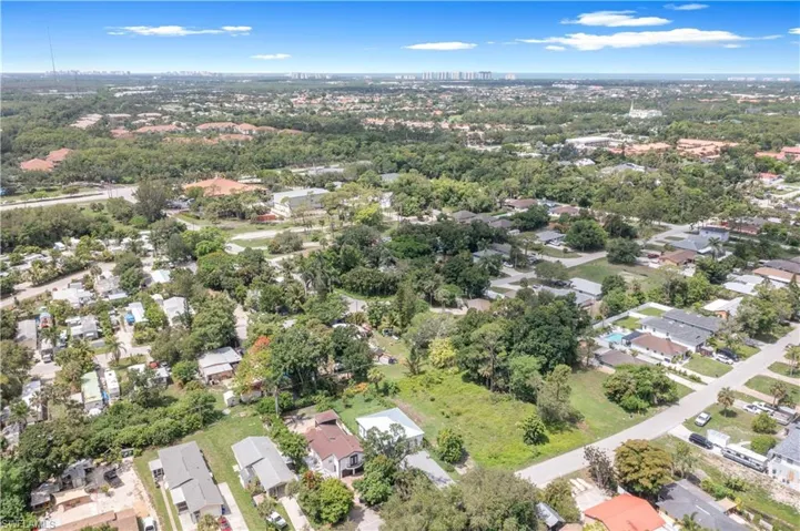 View of property location featuring nearby suburban area and a tree filled landscape