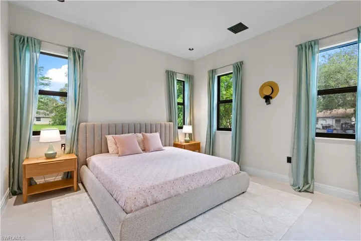 Carpeted bedroom with multiple windows