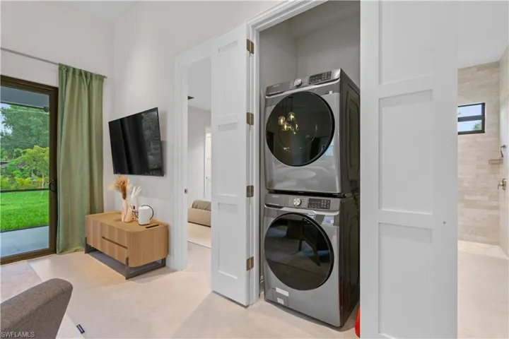 Washroom featuring stacked washer / dryer