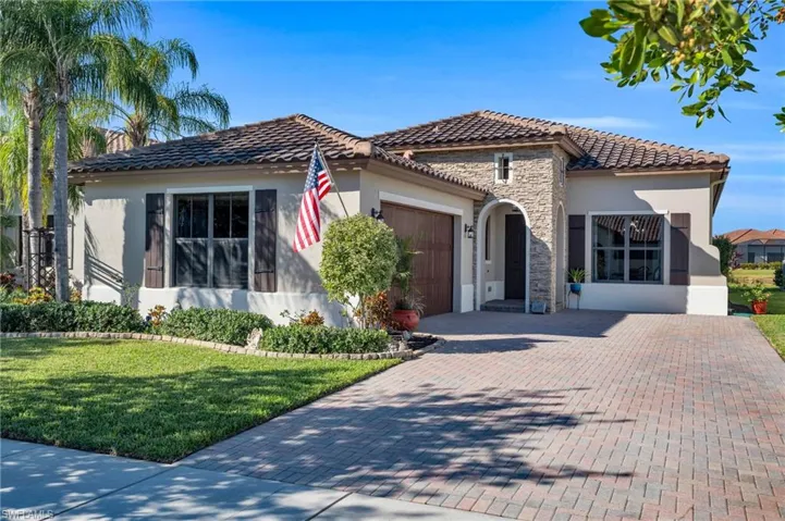 Mediterranean / spanish house featuring a front yard and a garage