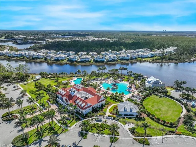 Aerial perspective of suburban area with a large body of water and a pool