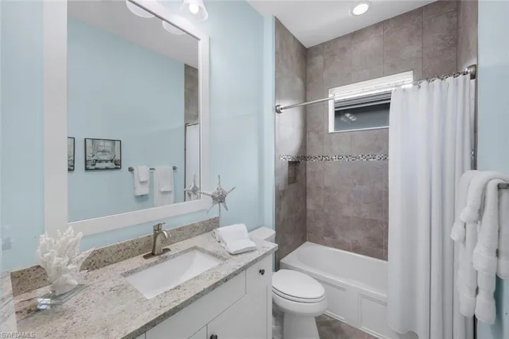 Bathroom featuring vanity and shower / bath combo with shower curtain