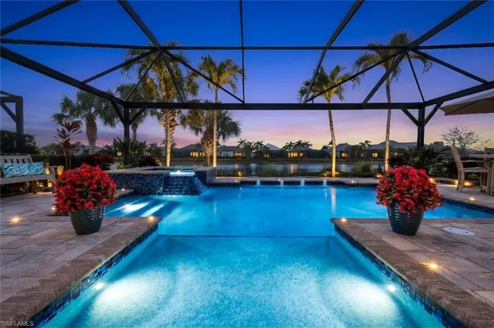 Pool at dusk with a patio, a pool with connected hot tub, a lanai, and a sunroom