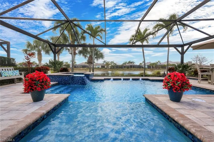 Combined pool / hot tub featuring a patio, a lanai, a sunroom, and a water view