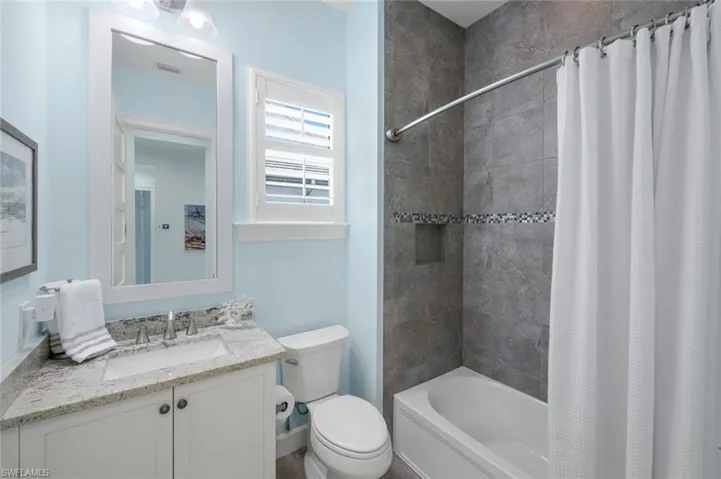 Bathroom with vanity and shower / bathtub combination with curtain