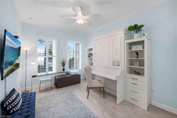 Office space featuring crown molding, light wood-style flooring, and ceiling fan