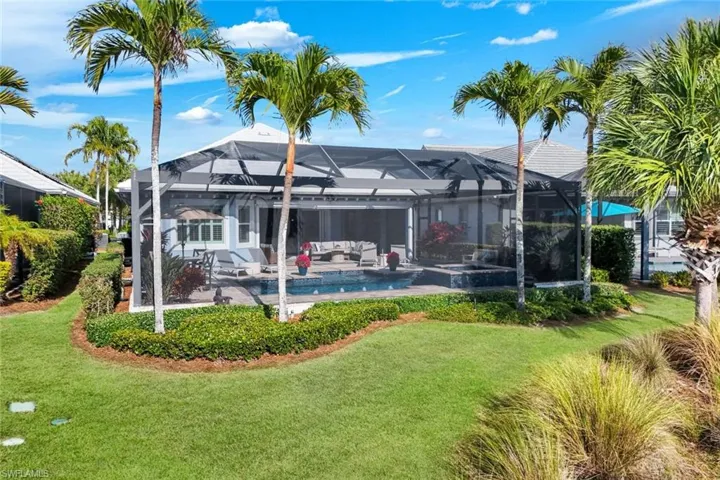 Back of house with an outdoor lounge area, an outdoor pool, a lawn, a lanai, and a patio