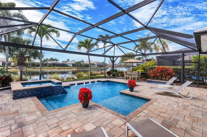 Integrated pool / hot tub with a lanai, a sunroom, a patio, a water view, and a residential view