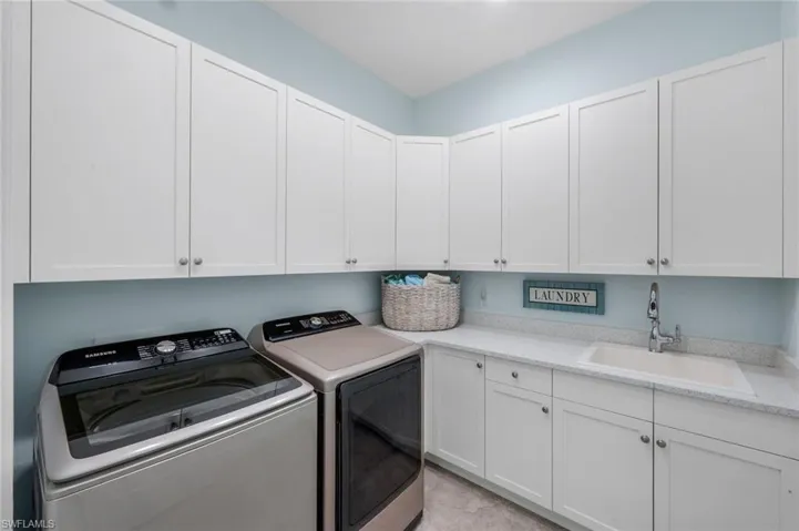 Laundry area featuring washing machine and clothes dryer and cabinet space