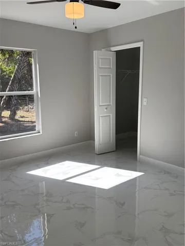 Unfurnished bedroom featuring ceiling fan and a closet