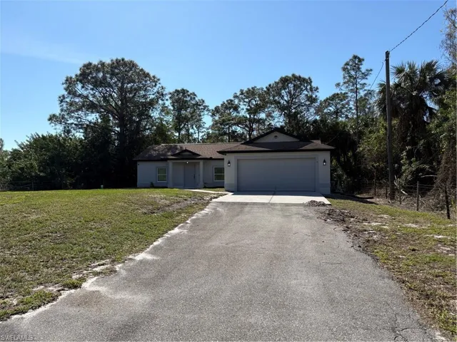Ranch-style home with a garage and a front lawn
