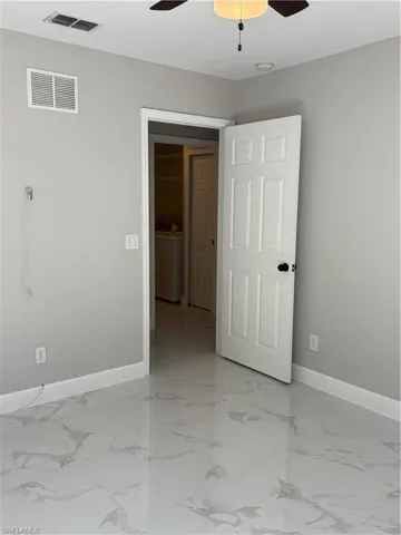 Unfurnished room featuring washer / dryer and ceiling fan