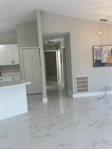 Kitchen with white cabinetry and lofted ceiling