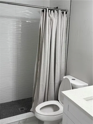 Bathroom featuring vanity, toilet, and a shower with shower curtain