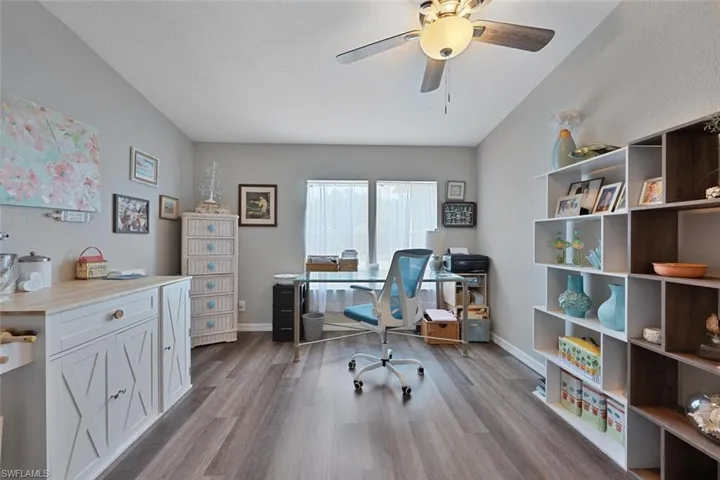 Office area featuring wood finished floors, a ceiling fan, and baseboards