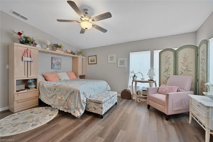 Bedroom with wood finished floors, ceiling fan, and baseboards