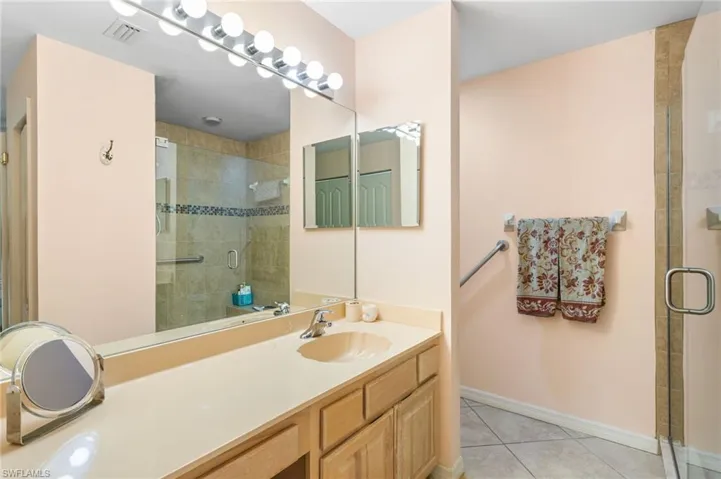 The first-floor primary bathroom has a large, beautifully tiled walk-in shower and extra-wide vanity.