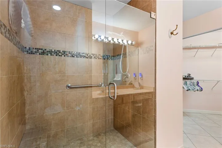 The first-floor primary bathroom has a large, beautifully tiled walk-in shower and extra-wide vanity.