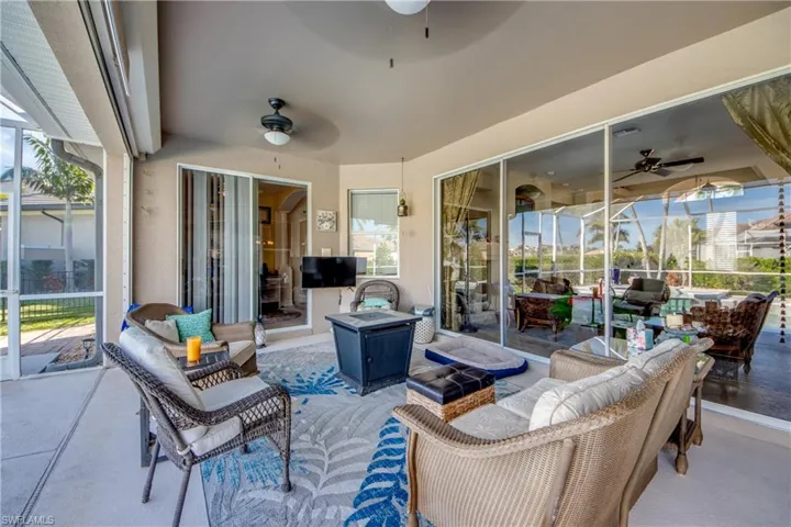 View of patio / terrace with a ceiling fan, a sunroom, outdoor lounge area, and glass enclosure