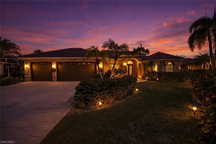 View of front of property with driveway, a garage, a yard, stucco siding, and a tiled roof