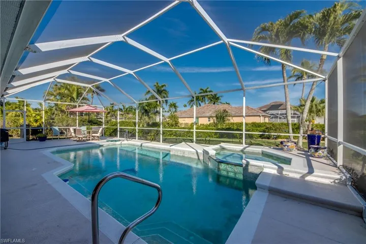 Combined pool / hot tub with a sunroom, a patio area, and glass enclosure