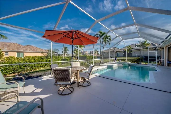 Combined pool / hot tub with a sunroom, a lanai, a patio area, and outdoor dining space